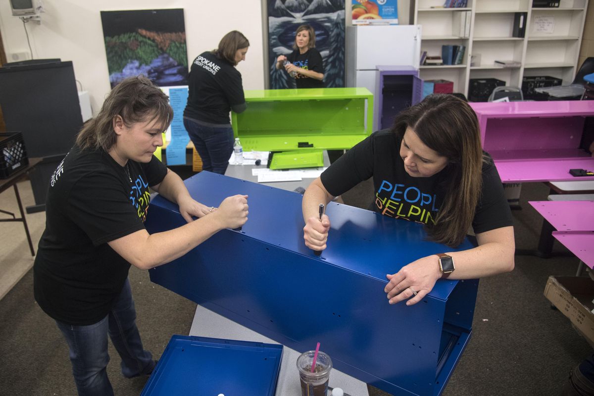 Chandra Sobosky, of STCU, left, and Stefanie Robinson, of Horizon Credit Union, right, assemble lockers, Thursday, Oct. 189, 2017, at the Volunteers of America Eastern Washington & Northern Idaho Crosswalk Youth Shelter in Spokane, Wash. Over 50 volunteers from area credit unions gathered to renovate and revitalize the pantry, entertainment center, kitchen clothes closet. The lockers will hold skateboards and backpacks near the shleter’s front entrance. (Dan Pelle / The Spokesman-Review)