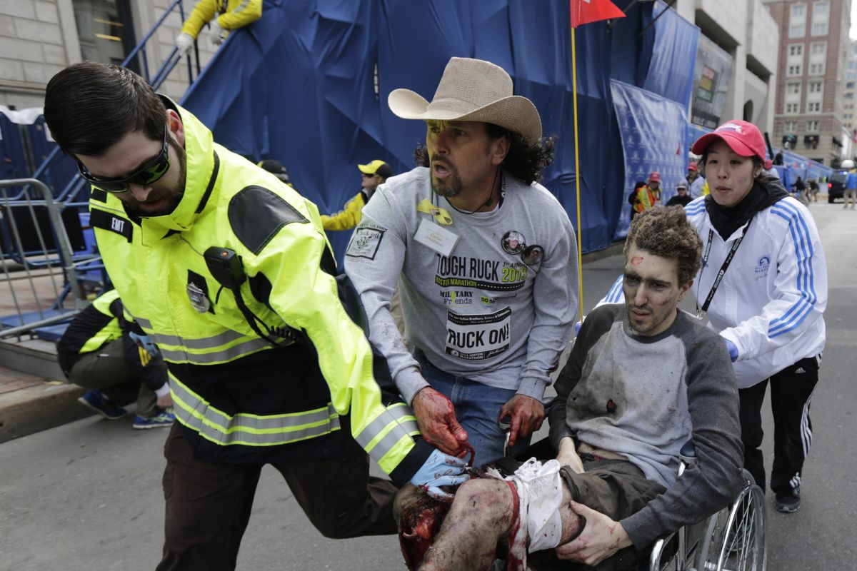 Medical responders run an injured man past the finish line the 2013 Boston Marathon following an explosion in Boston, Monday, April 15, 2013. Two explosions shattered the euphoria of the Boston Marathon finish line on Monday, sending authorities out on the course to carry off the injured while the stragglers were rerouted away from the smoking site of the blasts. (Charles Krupa / Associated Press)
