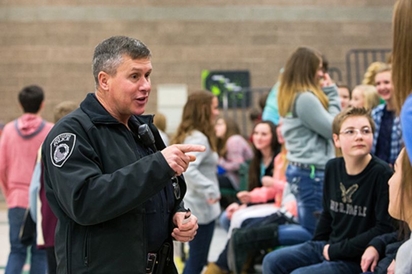 School Resource Officer Tom Sparks interacts with Woodland Middle School eighth grade students Monday during their lunch break. The district is planning to increase officer presence in more schools. (Shawn Gust/press)