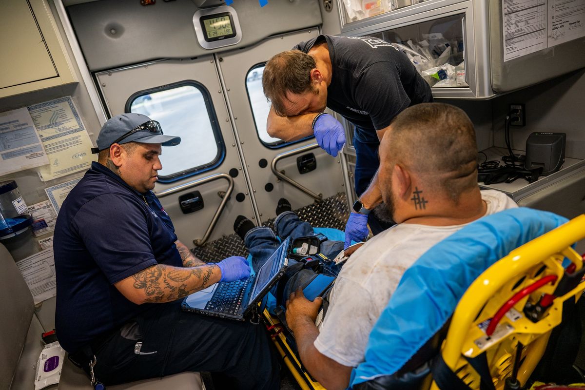 EMTs William Dorsey and Omar Amezcua assist a person after he called in for chest pain on June 29 in Eagle Pass, Texas. The patient called in reporting chest pain after working outside for hours.  (Brandon Bell/Getty Images )