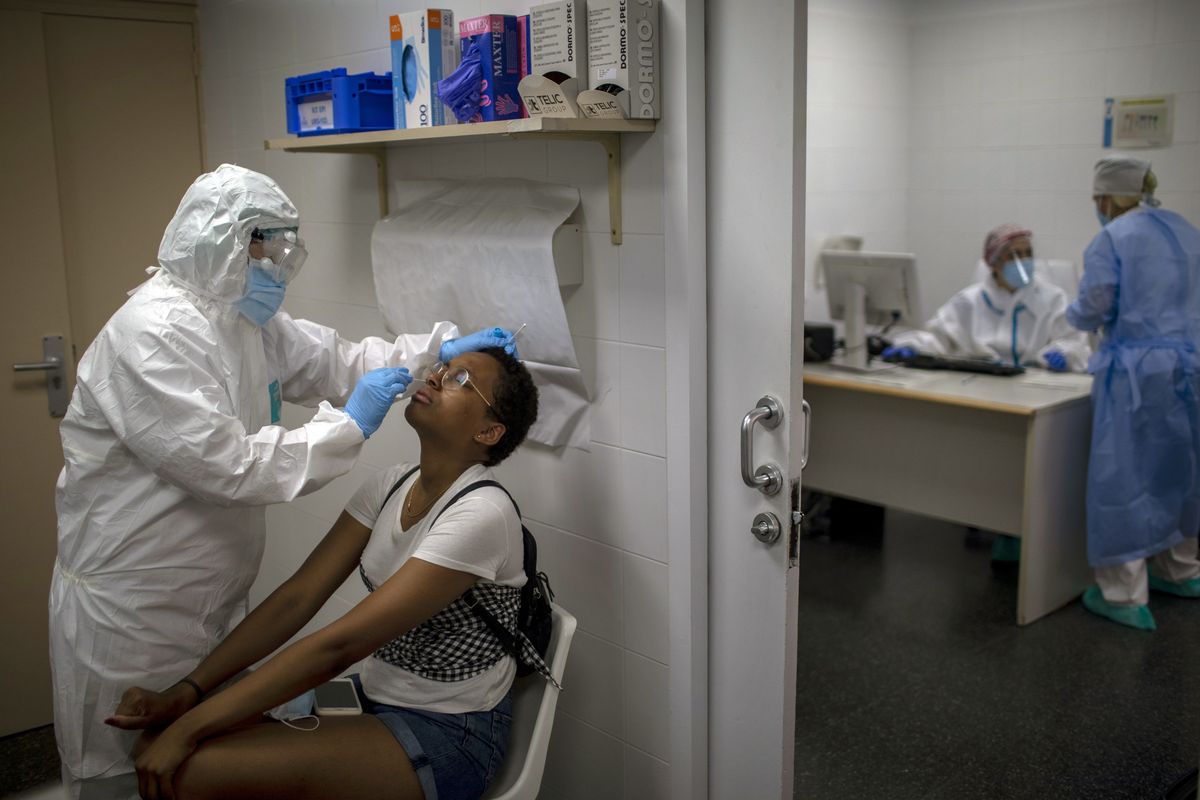A health worker takes a sample for a PCR test for the COVID-19 at a local hospital in Hospitalet, in Barcelona province, Spain, Tuesday, July 14, 2020. Outbreaks in northern Spain and in the city of Barcelona are not only prompting new restrictions for hundreds of thousands of people but also revealing the poor capacity that contact tracers have to track and control the spread of the new coronavirus.  (Emilio Morenatti)