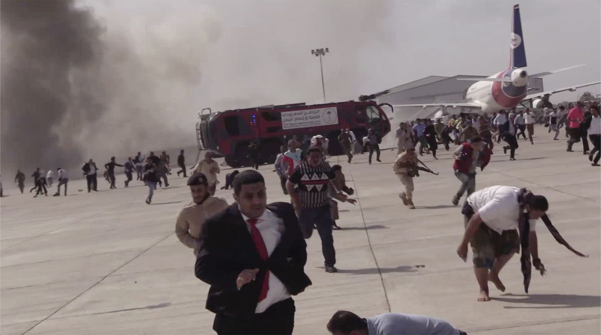 People run following an explosion at the airport in Aden, Yemen, shortly after a plane carrying the newly formed Cabinet landed on Wednesday, Dec. 30, 2020. No one on board the government plane was hurt but initial reports said several people at the airport were killed.  (Hani Mohammed)