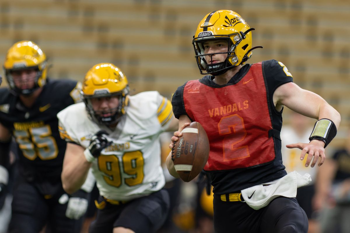 Idaho quarerback Jack Layne, right, scrambles under pressure from defensive lineman Trevor Miller during the annual spring game on Friday at the Kibbie Dome in Moscow.  (Geoff Crimmins/The Spokesman-Review)