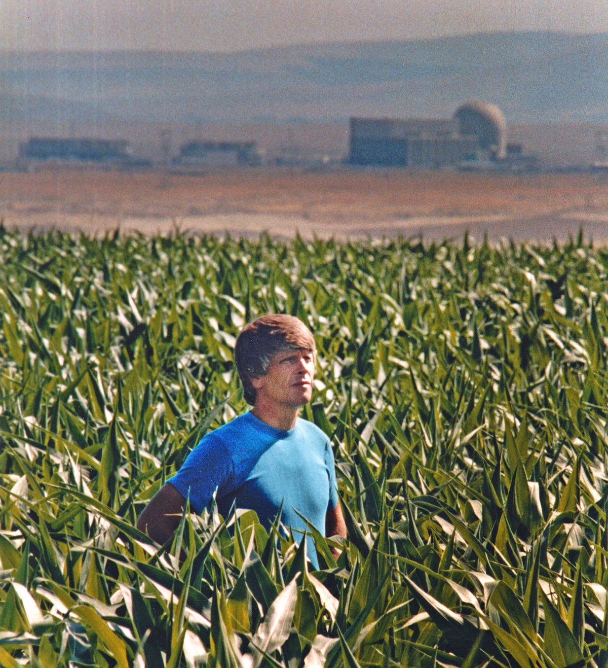 Hanford downwinder Tom Bailie stands in 1985 in one of the many fields that three generations of his family worked going back to the 1940s. In the background is the Hanford Nuclear Reservation.  (Christopher Anderson/The Spokesman-Review)
