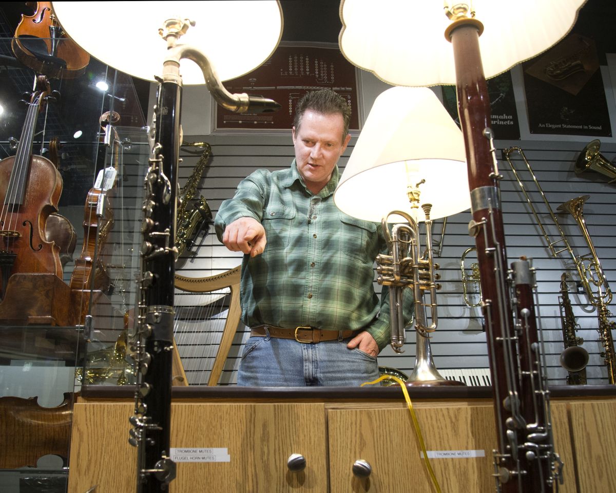 Allan Smith stands in Hoffman Music and talks about the lamps he has crafted from old musical instruments. He works at Hoffman and transforms old, unrepairable instruments into decorative items. The three lamps shown, from left, are made from a bass clarinet, a cornet and a bassoon. (Jesse Tinsley)
