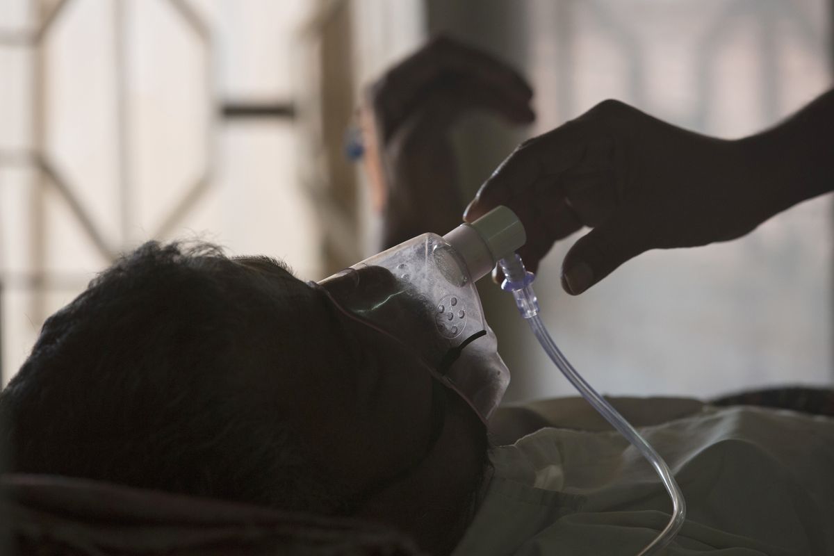 In this March 24, 2018 photo, a relative adjusts the oxygen mask of a tuberculosis patient at a TB hospital on World Tuberculosis Day in Hyderabad, India. The number of people killed by tuberculosis has risen for the first time in more than a decade, largely because fewer people got tested and treated as resources were diverted to fight the coronavirus pandemic, the World Health Organization said in a report released Thursday, Oct. 14, 2021.  (Mahesh Kumar A.)
