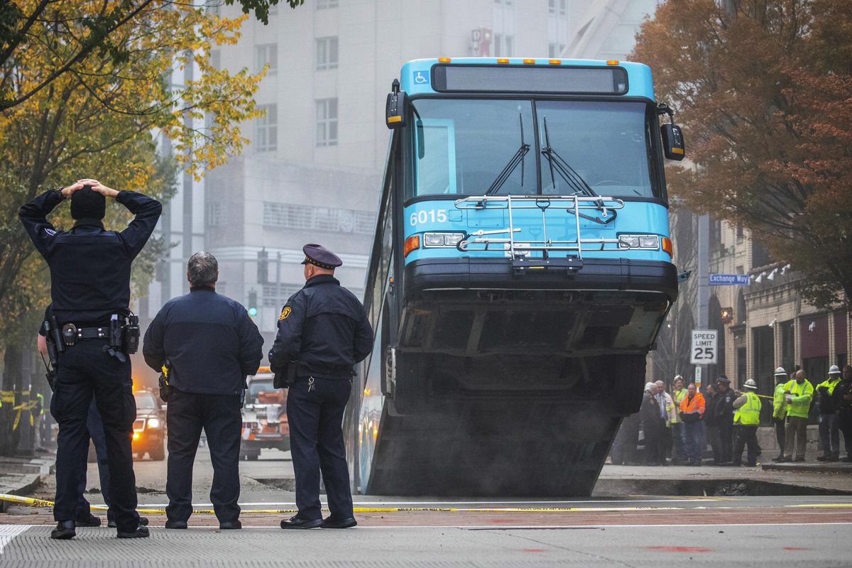 A bus sticks out of a large sinkhole in Pittsburgh on Oct. 28. (Andrew Rush / Associated Press)