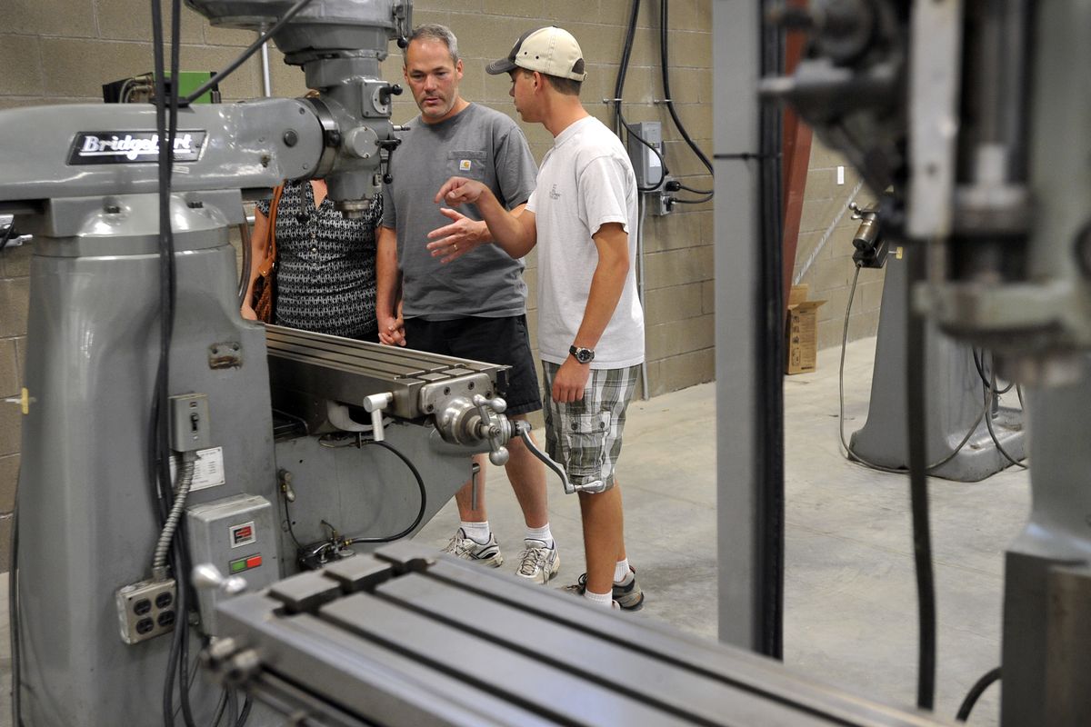 Todd Conery, left, explains the uses of a vertical mill to his son, Grant, as they tour the engineering design and automation department at the Kootenai Technical Education Campus on Tuesday on the Rathdrum Prairie. Grant is enrolled in the program. (Dan Pelle)