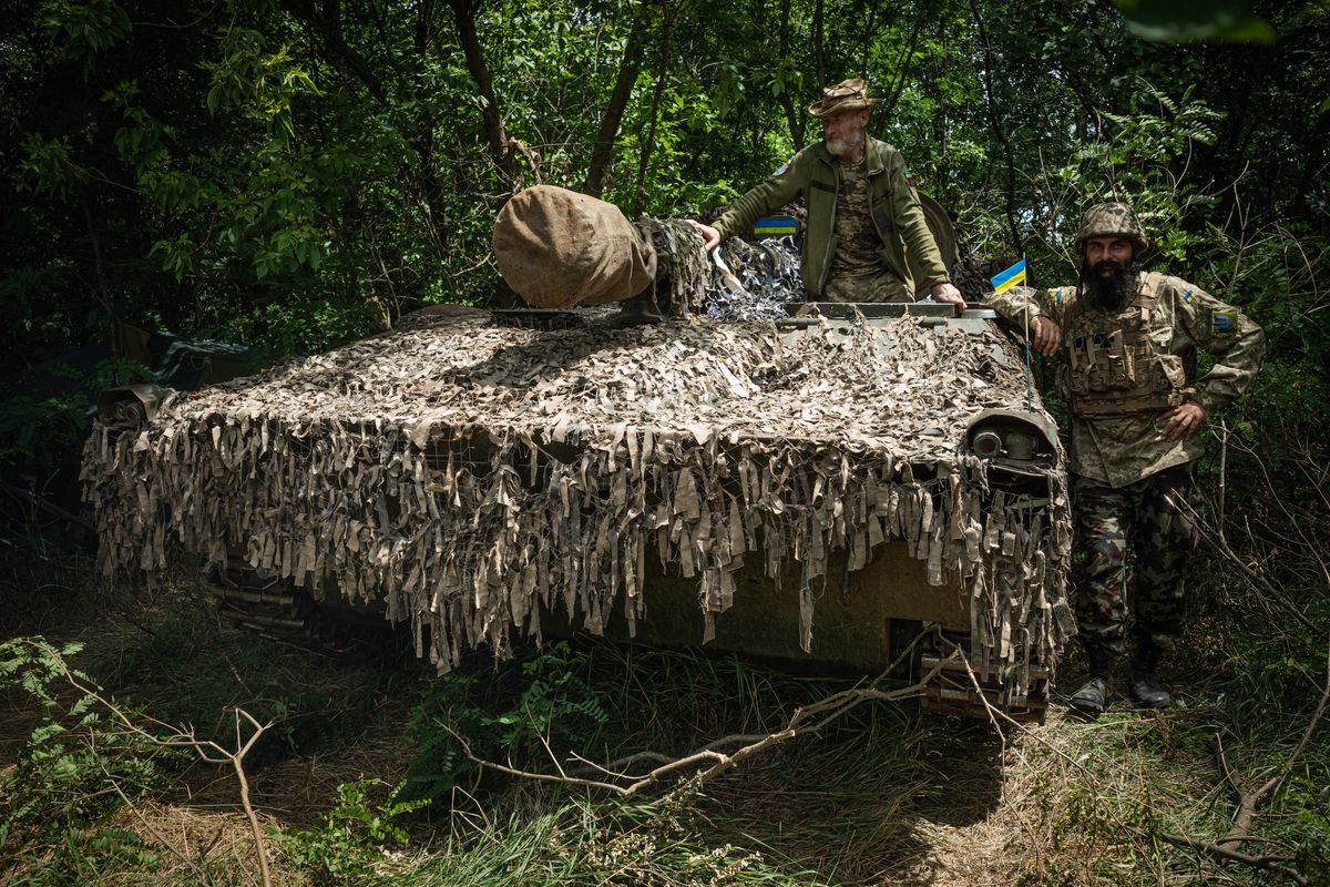 Ali Pirbudagov, 34, right, and Mykola Ostanyuk, 57, near their self-propelled gun that is older than Ali, in the Zaporizhzhia region of Ukraine on June 26.   (Serhiy Morgunov/For The Washington Post)