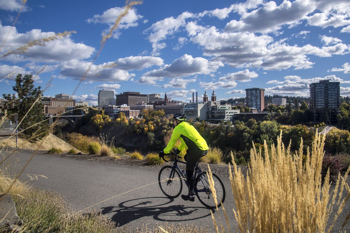 A cyclist heads east Sunday on the Centennial Trail through Kendall Yards on a picture perfect day in Spoklane. (Dan Pelle)