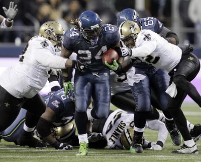 Former Seattle Seahawks running back Marshawn Lynch (24) breaks away from a tackle by the New Orleans Saints defenders to score a touchdown in the second half of an NFL NFC wild card playoff football game in 2011. (Elaine Thompson / Associated Press)