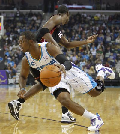 Hornets guard Chris Paul, left, helped New Orleans end the Miami Heat’s four-game winning streak with a victory at home. (Associated Press)