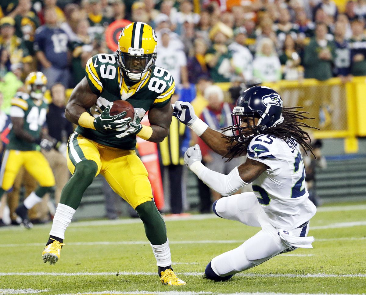 Packers’ James Jones catches a touchdown pass in front of Seahawks cornerback Richard Sherman for the game’s first score in Sunday night’s game at Green Bay. (Associated Press)