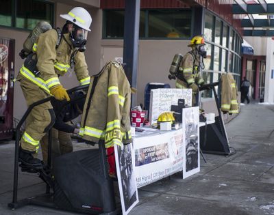 Spokane Valley Fire Department Station 1 Battalion Chief Andy Rorie, left, and Station 3 firefighter Paul Turcotte, right, work out on stair climbers during a fundraiser for the Leukemia and Lymphoma Society on Saturday at Rosauers in Spokane Valley. (Colin Mulvany)