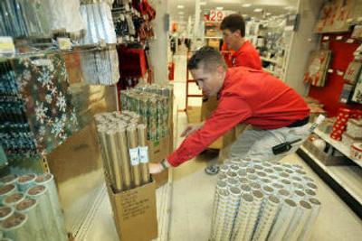 
Super Target manager Mike Cramer, front, and Sharon Sorenson stock holiday wrapping paper in the seasonal aisle of the Thorn Creek Shopping Center store in Thornton, Colo., on Monday.
 (Associated Press / The Spokesman-Review)