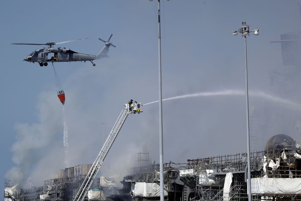 Fire crews battle the fire on the USS Bonhomme Richard, Monday, July 13, 2020, in San Diego. Fire crews continue to battle the blaze Monday after 21 people suffered minor injuries in an explosion and fire Sunday on board the USS Bonhomme Richard at Naval Base San Diego.  (Gregory Bull)