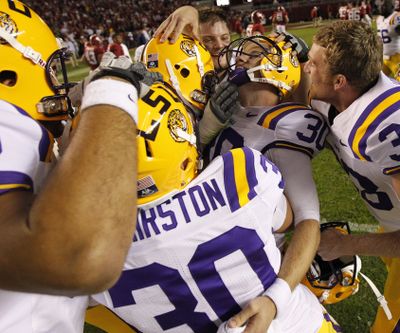 LSU kicker Drew Alleman (30) is surrounded by teammates after beating Alabama. (Associated Press)