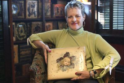 
Mary Ann Sanger holds up the first photo album in her 110-album collection, which her husband bought for her 25 years ago. Sanger's albums are bound in a variety of materials, including celluloid like the one she is holding, leather and velvet. 
 (The Spokesman-Review)