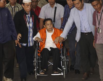Indonesian House Speaker Setya Novanto sits on a wheelchair as he is escorted by investigators and aides upon arrival at Corruption Eradication Commission office in Jakarta, Indonesia late Sunday, Nov. 19, 2017. Indonesia’s anti-graft commission arrested the top politician who for weeks evaded questioning over his alleged role in the theft of $170 million of public money. (Associated Press)
