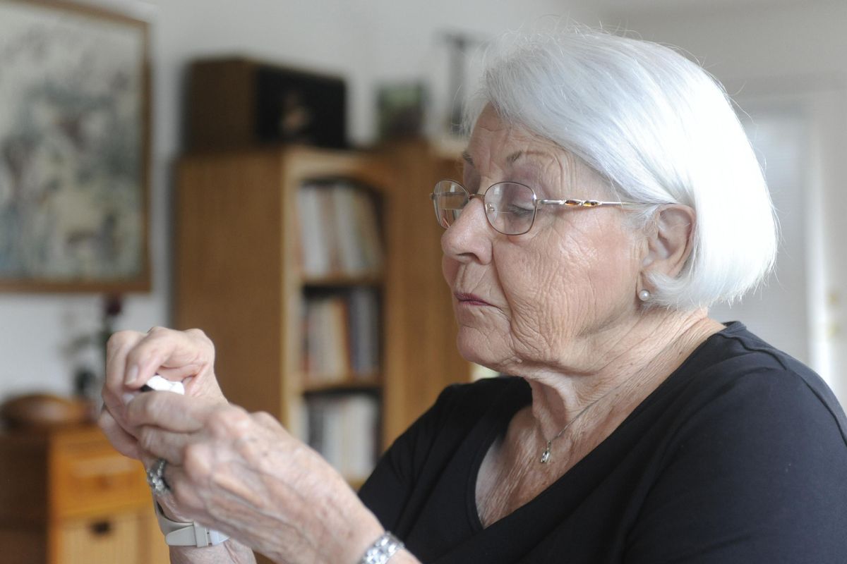 Dorothea Hahn King examines a dog tag at her home in Cashmere, Wash., Thursday, July 30, 2009. The dog tag was found on Guadalcanal in 2003 and belonged to her brother, Walter Raymond Hahn of Spokane, who died in battle on the island in WWII. Voter records helped a Spokesman-Review journalist to find Hahn King and return the tag. (Jesse Tinsley / The Spokesman-Review)