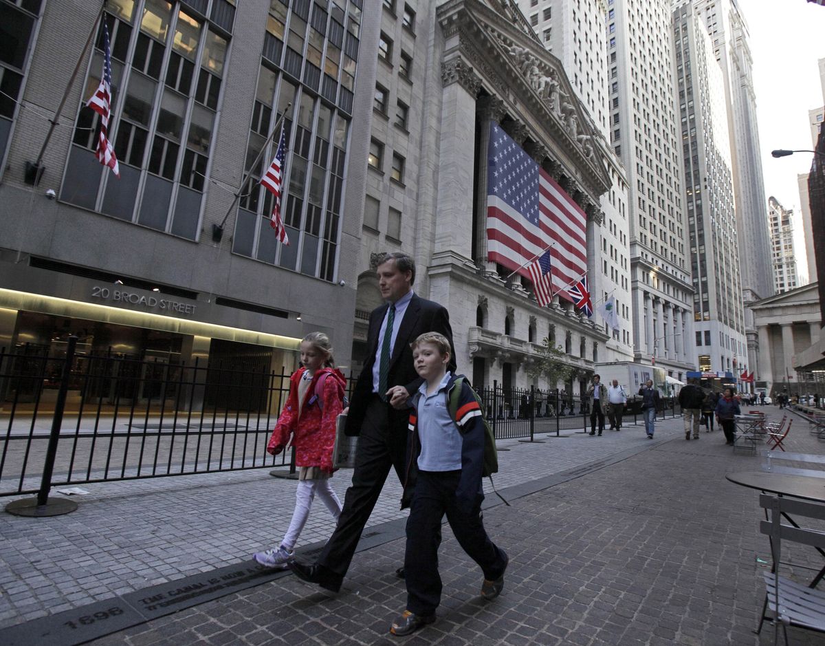 A man with two children passes the New York Stock Exchange, Thursday morning, Oct. 18, 2012.  A Bangladeshi man, 21-year-old Quazi Mohammad Rezwanul Ahsan Nafis, snared in an FBI terror sting, considered targeting a high-ranking government official and the New York Stock Exchange before authorities say he raised the bar further by picking one of New York City's most fortified sites: The Federal Reserve. (Richard Drew / Associated Press)