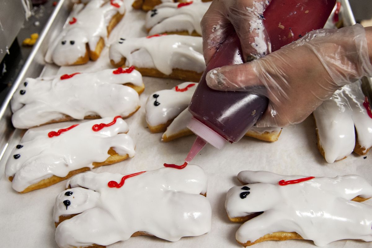 A squeeze of raspberry is added to top off the zombie doughnuts at the Dawn of the Donut store in Spokane. (Dan Pelle)