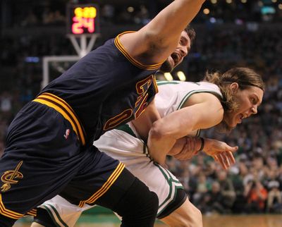 Cleveland Cavaliers forward Kevin Love, left, is dragged by the arm by Boston Celtics center Kelly Olynyk during the first quarter of their first-round NBA playoff basketball game in Boston in 2015. The play resulted in an injury to Love that forced him from the game. (Thomas Ondrey / Associated Press)