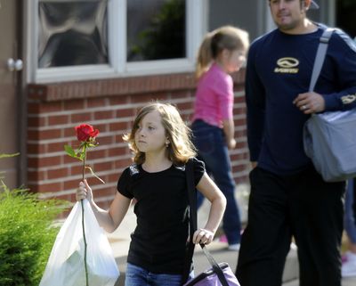 Izabel Garcia heads toward class to present her third-grade teacher, Monica Headley, a rose on the first day of school at Linwood Elementary. Headley teaches a combined second- and third-grade class and taught Izabel last year. (Dan Pelle / The Spokesman-Review)
