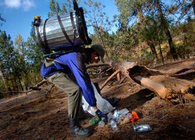 
Erik Overland picks up trash at the 5th Annual Spokane River Cleanup on Saturday. Overland strapped a trash can to his back so he could haul more.
 (Ingrid Barrentine / The Spokesman-Review)