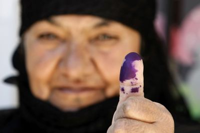 A Lebanese woman shows her ink-stained thumb after casting her vote Sunday in Saadnayel,  Lebanon. (Associated Press / The Spokesman-Review)