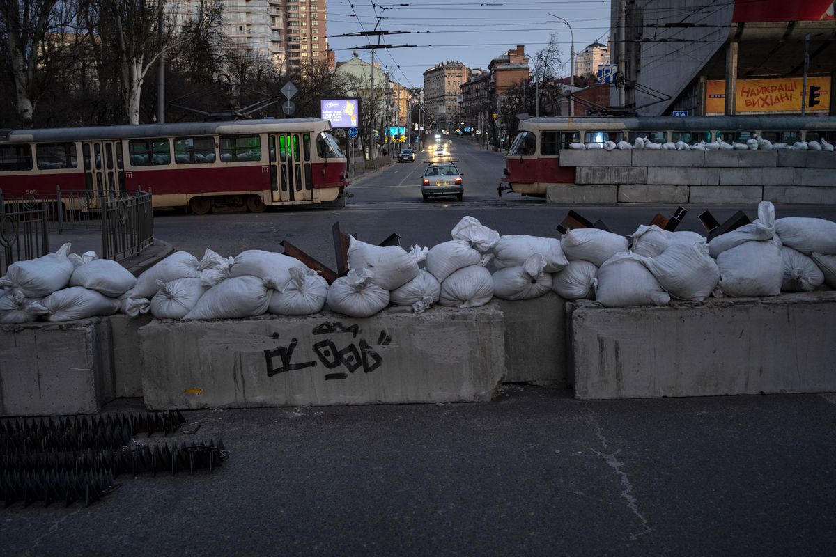 A driver passes through a barricade built by territorial defense units downtown in Kyiv, Ukraine, Saturday, March 19, 2022.  (Rodrigo Abd)