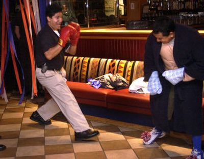 
 Red Robin downtown Spokane kitchen manager Miguel Pachco, left, challenges chef Gerardo Silva, boxing gloves vs. oven mitts, while Silva waits for his turn to compete in the regional Burger Championships at the Spokane Valley Red Robin. 
 (Liz Kishimoto / The Spokesman-Review)