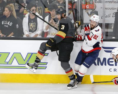 Washington Capitals center Evgeny Kuznetsov, right, winces as he is checked by Vegas Golden Knights defenseman Brayden McNabb during the first period in Game 2 of the  Stanley Cup Finals on Wednesday in Las Vegas. (Ross D. Franklin / Associated Press)