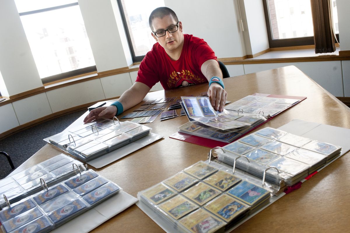 Alex Koch shorts through his collection of Pokémon cards as he poses for a photo on Jan. 31, at The Spokesman-Review in downtown Spokane. Koch is the 2013 Pokémon City Masters Division champion and owns more than 10,000 Pokémon cards. (Tyler Tjomsland)
