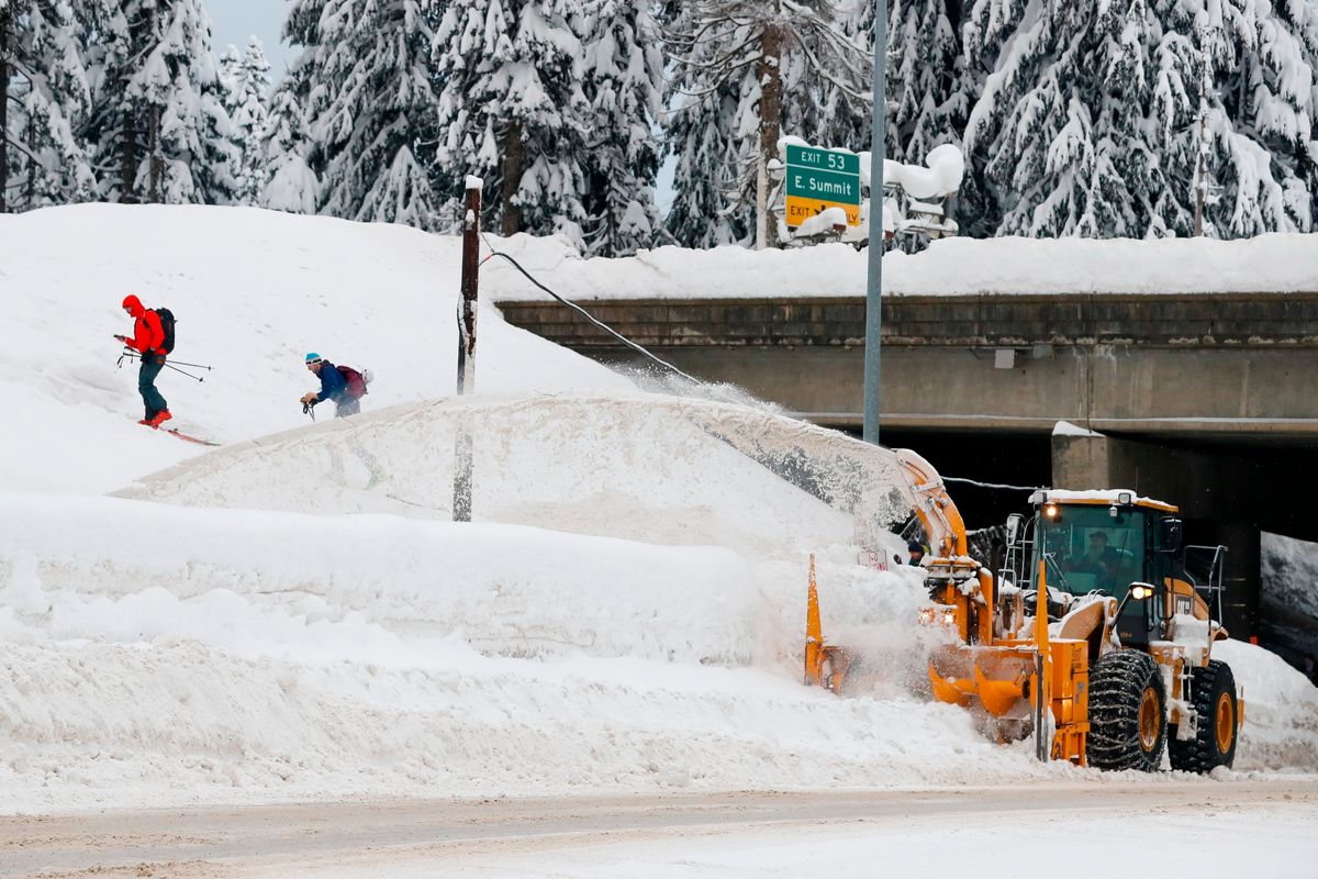 A Washington State Department of Transportation snowblower clears the road under I-90 at Summit West as backcountry skiers head up the Pacific Crest Trail after a heavy snowfall at Snoqualmie Pass. Authorities say Snoqualmie Pass has received the highest snowfall in 20 years as of Jan. 3.  (Jennifer Buchanan)