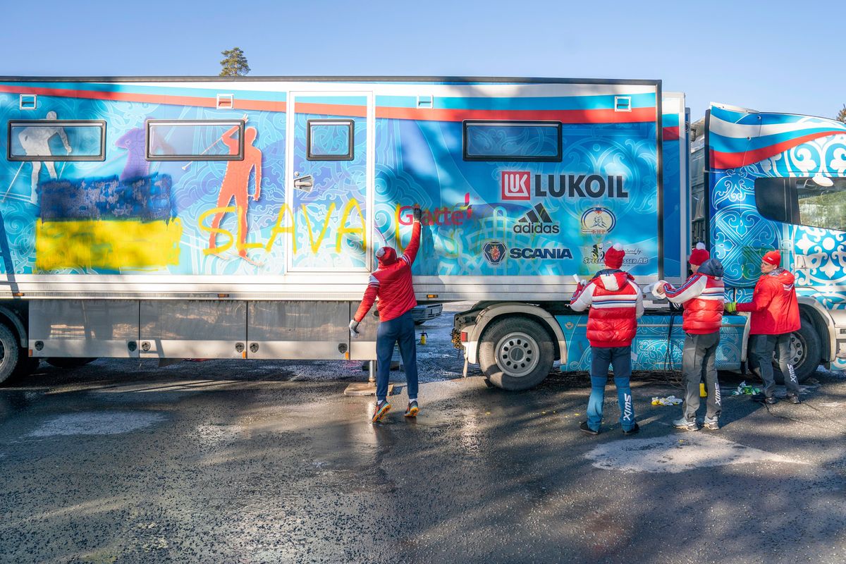 Members from the Russian cross-country national team try to remove a Ukrainian flag and writing reading "Glory to Ukraine" from the side of the trailer of the Russian cross-country national team, in Holmenkollen. near Oslo, Wednesday, March 2, 2022. In Norway, Russian cross-country skiers, who won 11 medals at the Beijing Olympics, were heading home after being excluded from competition by the International Ski Federation, known as FIS. The decision came after a three-day standoff with Norwegian ski officials, who said they would refuse to let Russians and Belarusians race if FIS maintained its previous policy of allowing them to compete as neutral athletes.  (Torstein Boee)