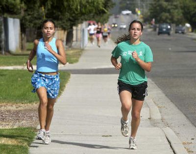 
East Valley's Lauren Bergam, left, and Devon Borja take the lead in a training run. 
 (The Spokesman-Review)
