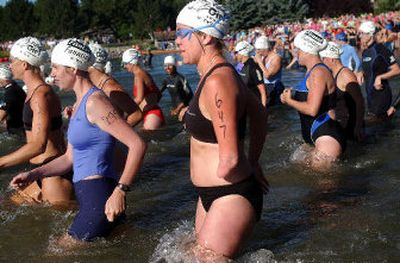 
Carrie Davis enters the water at the start of the Valley Girl Triathlon July 17 in Liberty Lake. 
 (Liz Kishimoto / The Spokesman-Review)