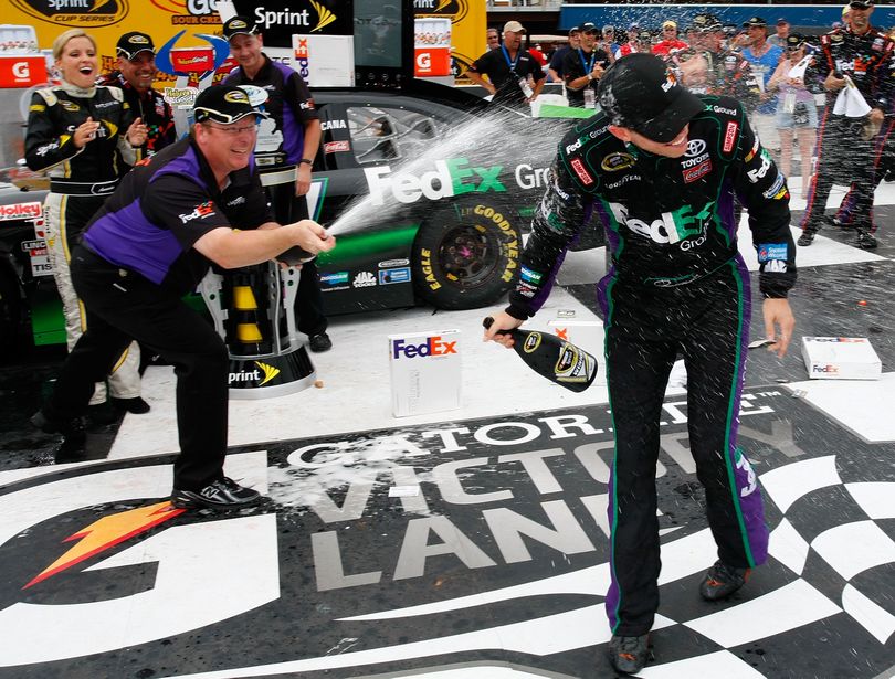 (Left to right) Crew chief Mike Ford sprays his driver Denny Hamlin in Michigan International Speedway's Victory Lane after winning the Heluva Good! Sour Cream Dips 400 Sunday in Brooklyn, Mich. (Photo courtesy of Geoff Burke/Getty Images for NASCAR) (Geoff Burke / Getty Images North America)