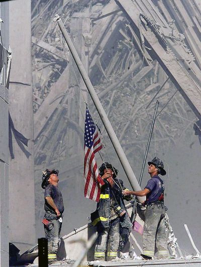 Brooklyn firefighters George Johnson, left, of ladder 157, Dan McWilliams, center, of ladder 157, and Billy Eisengrein, right, of Rescue 2, raised a flag at the World Trade Center in New York, in this Sept. 11, 2001, file photo. The flag was believed lost, but investigators believe it’s now turned up in Everett, Washington. (THOMAS E. FRANKLIN / AP)