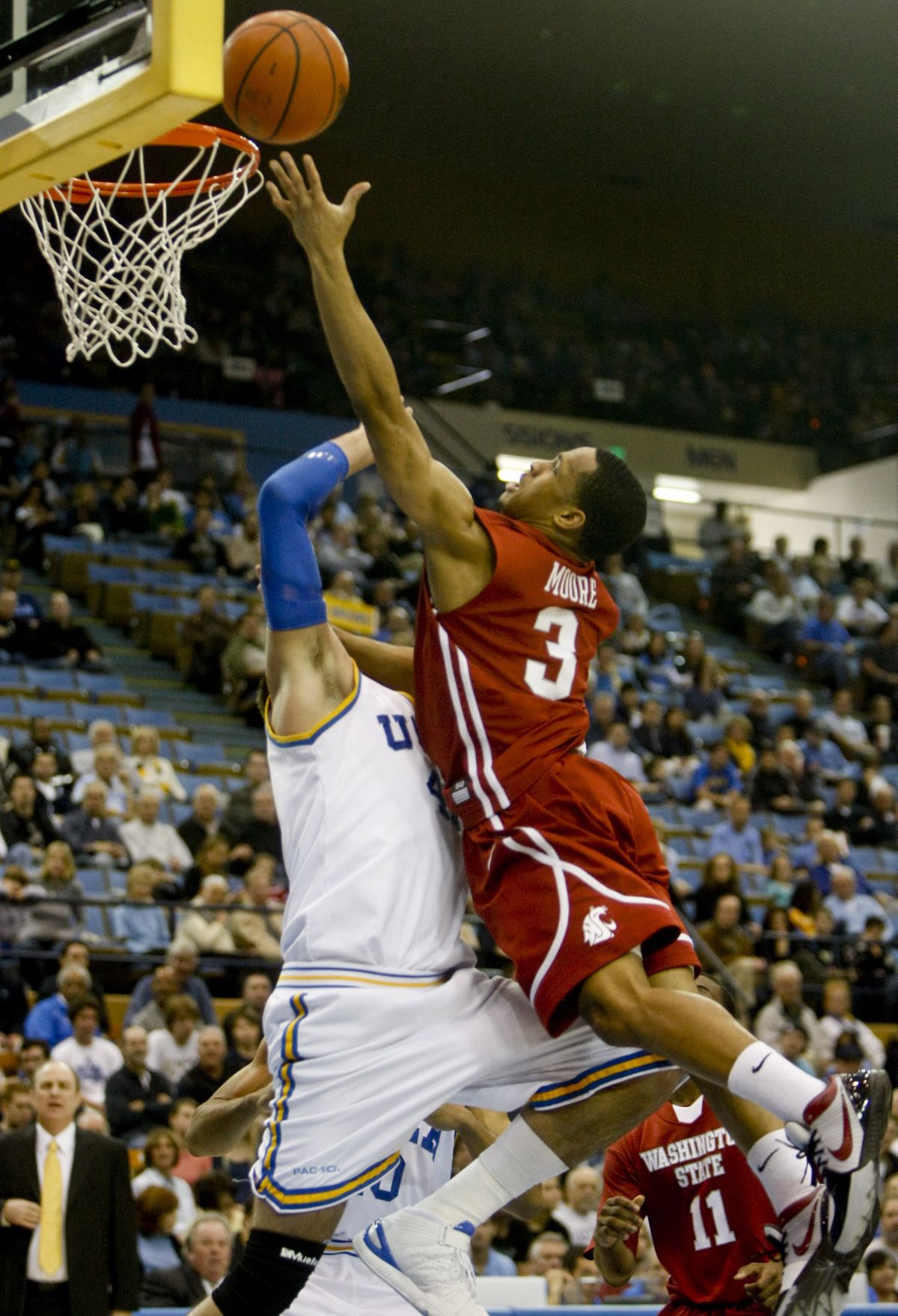 Washington State guard Reggie Moore, right, lays the ball in over UCLA forward Nikola Dragovic during the first half of an NCAA college basketball game, Saturday, Jan. 23, 2010, in Los Angeles. (Bret Hartman / Associated Press)