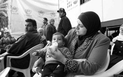 
An woman feeds her baby last month as she waits with other Iraqi refugees for a turn at the office of the U.N. Higher Commissioner for Refugees to register her name for residence near Damascus, in Syria. 
 (Associated Press / The Spokesman-Review)