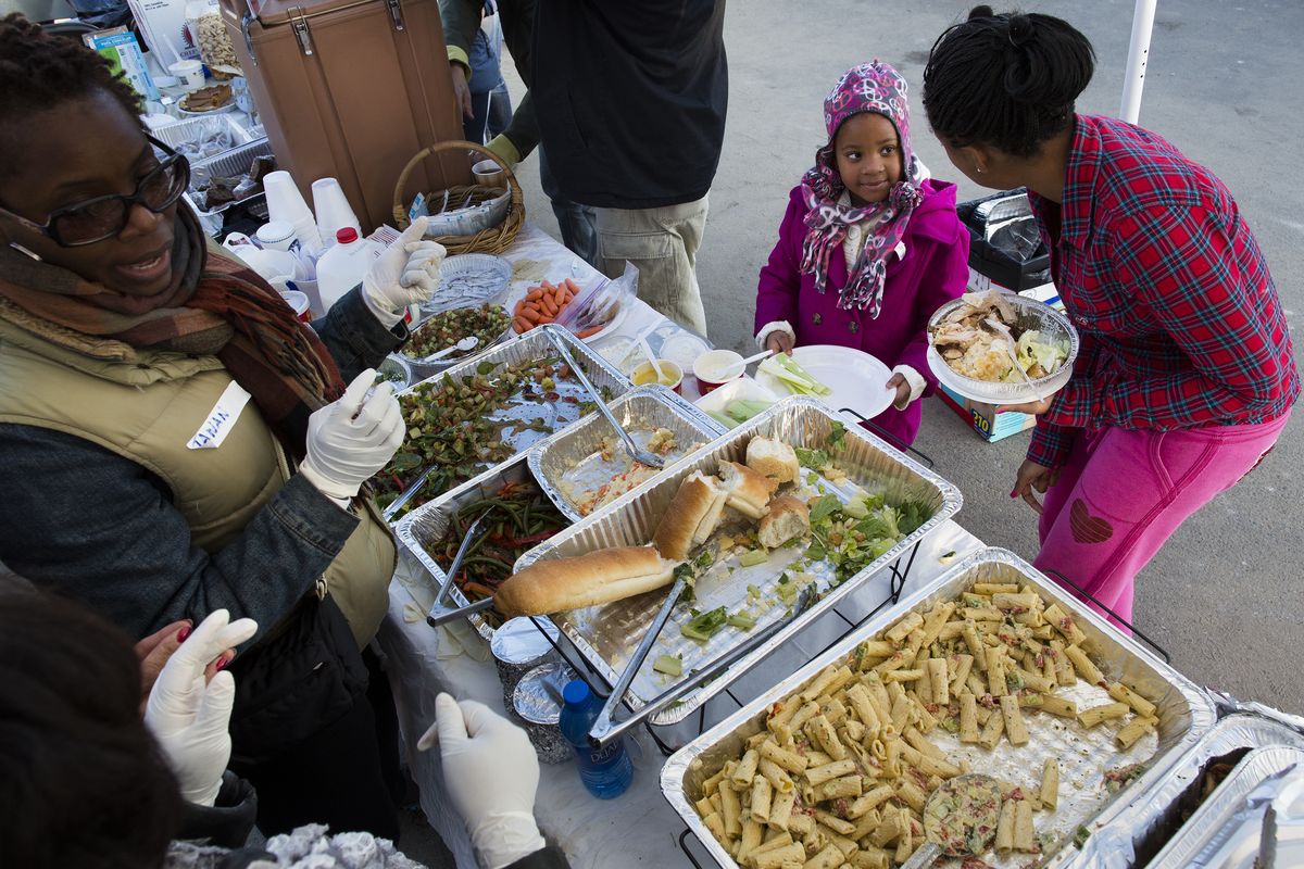 Rockaway, Queens, residents wait in line for a free Thanksgiving dinner on Thursday in New York in an area still recovering from Superstorm Sandy. (Associated Press)