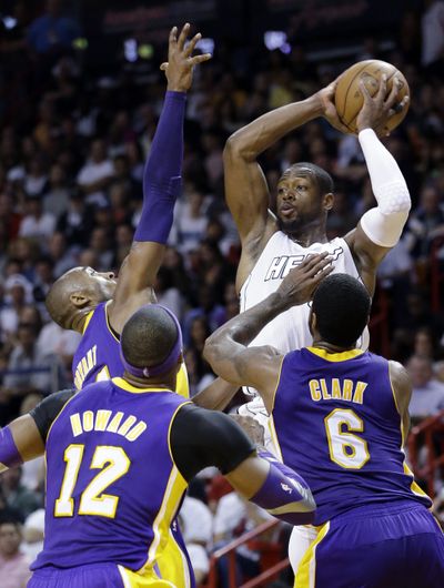 Miami Heat guard Dwyane Wade looks to dump off a pass to an open teammate as he is swarmed by a horde of Lakers defenders. (Associated Press)