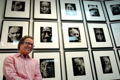 
Mark Story, photographer and author, poses in front of a collection of his photographs titled 