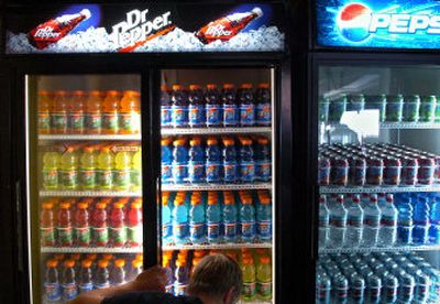 
Rogers High School student Bryan Clark arranges bottles of Gatorade on Thursday in the Pirate Pit,  the on-campus store managed by student. Sweetened sodas are banned from many Spokane County and North Idaho schools. 
 (Holly Pickett / The Spokesman-Review)
