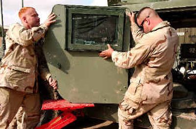 
U.S. Navy Seabees fit armored doors to a Humvee at a military base near Fallujah in November. Washington National Guard soldiers were able to 