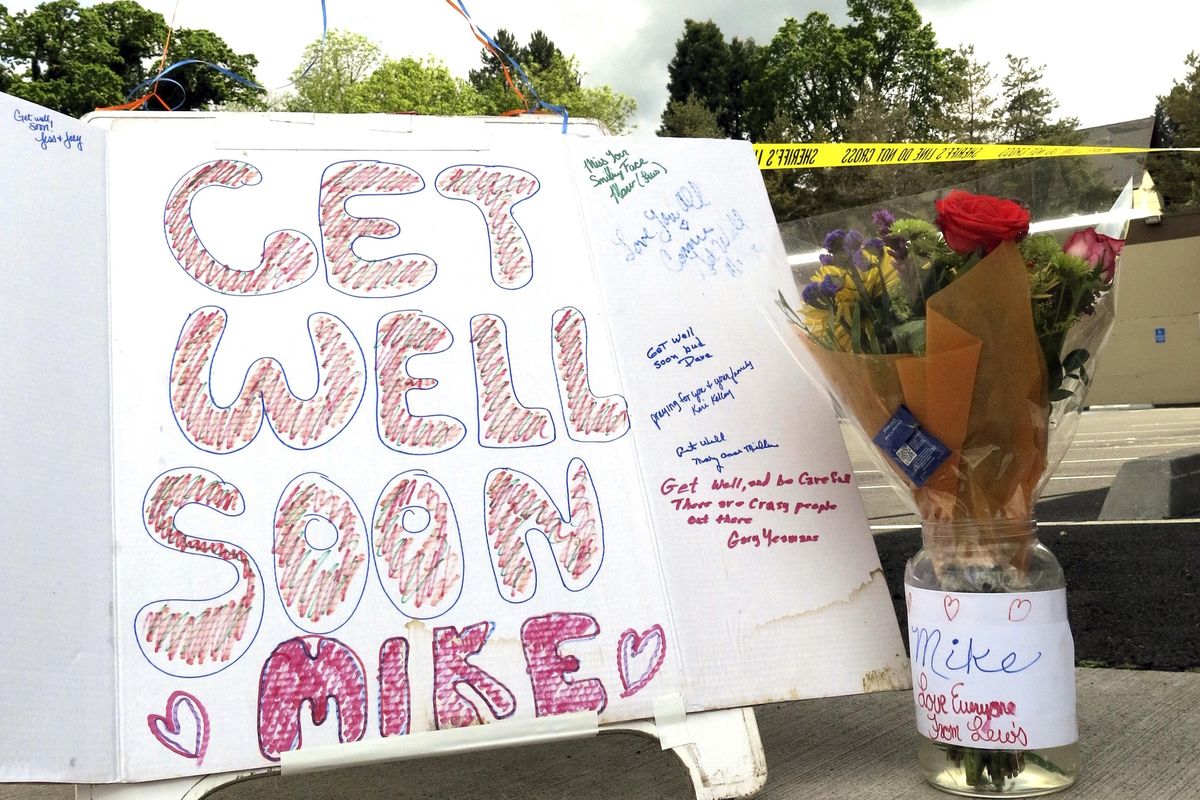 Well-wishing messages and flowers for an injured employee are shown outside a grocery store in Estacada, Ore., Monday, May 15, 2017. Police say a man carrying what appeared to be a human head stabbed an employee at the grocery store. (Gillian Flaccus / Associated Press)