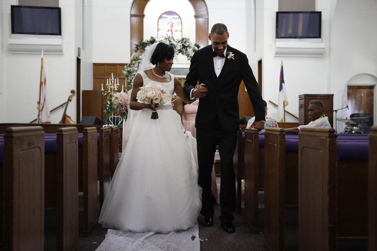 Two-time Olympic jumper Jamie Nieto, right, who was paralyzed from neck down 15 months ago after a spinal cord injury, pauses for a moment while walking down the aisle with his bride Shevon Stoddart after their wedding ceremony Saturday, July 22, 2017, in El Cajon, Calif. Step by halting step, Nieto made good on his vow to walk his new wife down the aisle of the church and out the door to a waiting limousine. (Jae C. Hong / Associated Press)