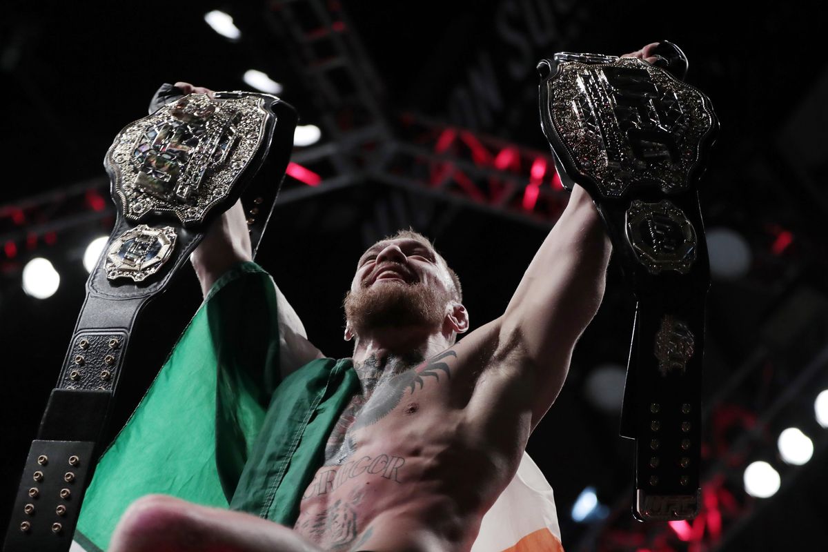 Conor McGregor holds up his title belts after he defeated Eddie Alvarez during a lightweight title mixed martial arts bout at UFC 205, early Sunday, Nov. 13, 2016, at Madison Square Garden in New York. (Julio Cortez / Associated Press)